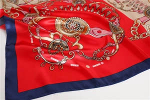 Close-up of red and navy satin silk square scarf with golden chain equestrian pattern