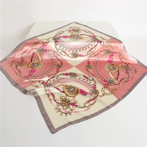 Detail of pink and beige satin scarf with golden chain pattern and silk luster finish
