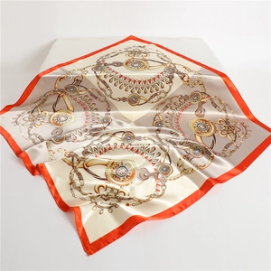 Close-up of silk-like satin scarf featuring equestrian chain prints and orange borders