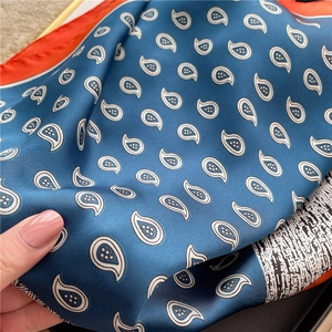 Navy blue paisley silk scarf with contrast orange border and elegant satin texture