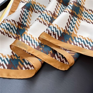 Detailed view of houndstooth silk scarf with smooth satin texture and neat hemmed edges