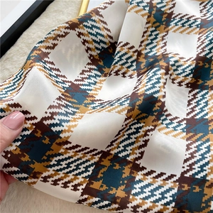 Houndstooth pattern silk scarf in teal and brown, close-up texture and soft fabric drape