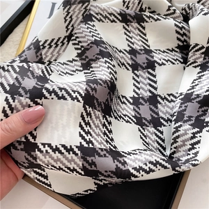 Detailed close-up of houndstooth silk scarf showing premium glossy texture and soft drape