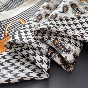 Detailed close-up of vintage paisley and houndstooth silk scarf with soft drape texture