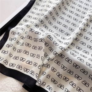 Detailed view of the butterfly print satin scarf with soft pleats and black borders