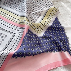 Detail view of lace paisley silk scarf with floral patterns on soft plush background