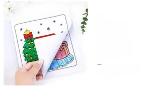 Detail of thick paper interior pages showing Christmas tree drawings for coloring