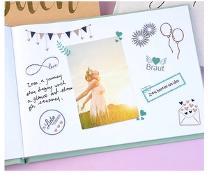 Detailed view of sage green wedding guest book pages with DIY stickers and photo