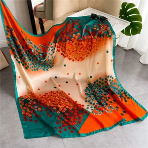 Artistic color block silk scarf featuring abstract tree patterns draped on a sofa