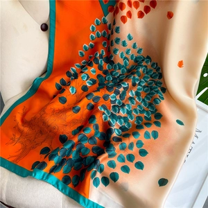 Close-up of abstract artistic printed silk scarf with orange and teal floral patterns