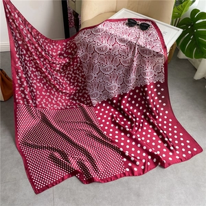 Detail of burgundy paisley and polka dot silk scarf draped elegantly on a chair