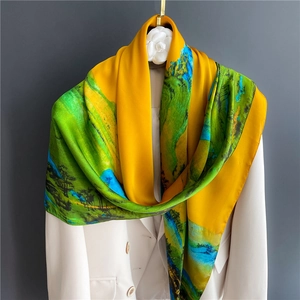 Close-up of artistic oil painting silk scarf draped over a white blazer on a gold hook
