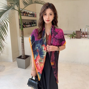 Detail of elegant peony print silk scarf with vibrant floral patterns and yellow borders