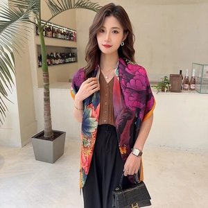 Detail of silk-satin scarf with vibrant floral print and elegant glossy texture