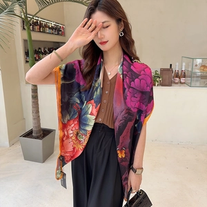 Detail of silk-like satin shawl with large peony floral print and hand-stitched orange edges