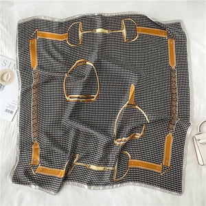 Detail of luxury silk scarf with equestrian horsebit print and houndstooth pattern