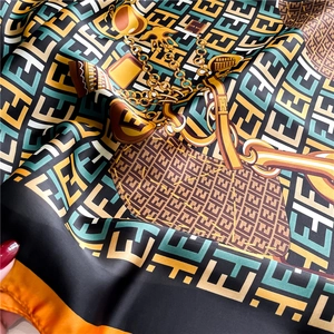 Detail shot of silk scarf fabric showing draped texture and classic geometric patterns
