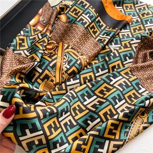 Detailed view of silk scarf with equestrian leather straps and vintage monogram patterns
