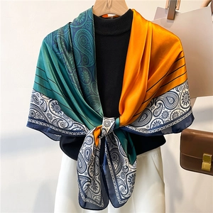Detail of silk-textured scarf with paisley pattern and geometric stripes in vivid colors