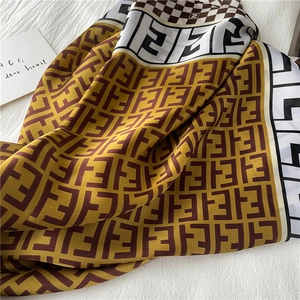 Detail of luxury silk scarf showing double F monogram pattern and contrast striped edges