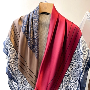 Detailed close-up of paisley pattern and glossy silk texture on a large square scarf