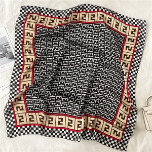 Detailed view of luxury houndstooth silk scarf with monogram print and satin texture