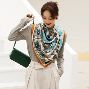 Elegant silk scarf with blue architectural patterns styled over a white blazer