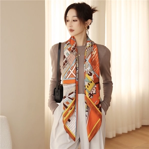 Close-up of elegant orange silk scarf with vintage architecture print draped on neck