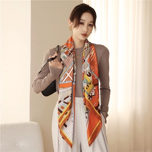 Detail of silk scarf with orange architectural print styled on model shoulder