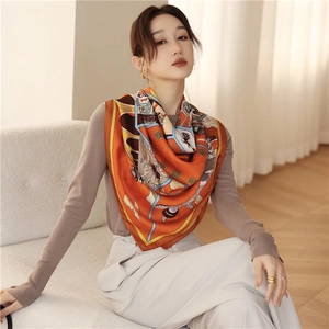 Detail of silk scarf showing vibrant orange tones and elegant Chinese architecture pattern