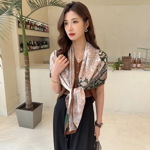 Detail of silk-satin scarf with vintage floral patterns draped in an elegant setting
