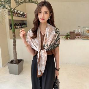 Detail of elegant silk scarf with floral print and satin finish on Asian model