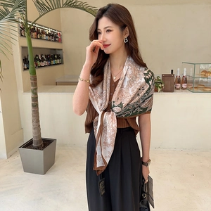 Detail of vintage floral silk scarf featuring elegant patterns and fine hemmed edges