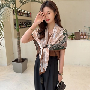 Detail of elegant silk-textured square scarf with vintage floral prints and premium brown edges