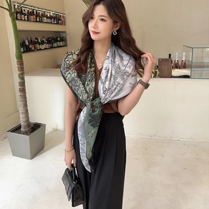 Close-up of silk square scarf with green jungle pattern featuring tiger and birds