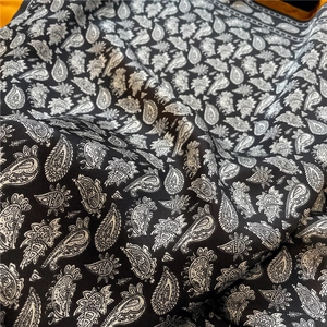 Gros plan d'une écharpe de luxe en soie noire avec motif cachemire et texture lisse