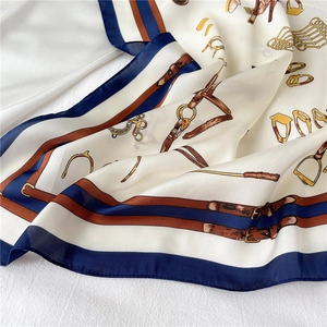 Detail of luxury silk-feel scarf with equestrian horse bit pattern and nautical blue border