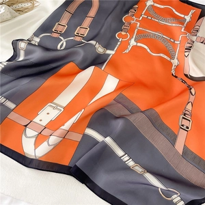 Elegant chain print silk scarf in orange and grey with equestrian bridle buckle patterns