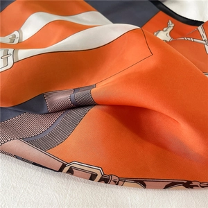 Detail view of the silk scarf featuring horse harness patterns and luxury buckles