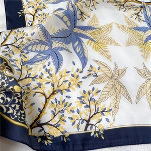 Gros plan d'un foulard en soie avec imprimés feuilles et texture lisse brillante