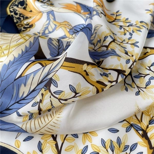Gros plan d'un foulard en soie aux imprimés de feuilles élégants en bleu et doré