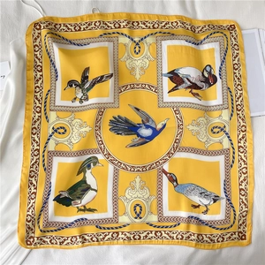 Detail van een vierkante zijden sjaal met klassieke vogeltekeningen en elegante patronen