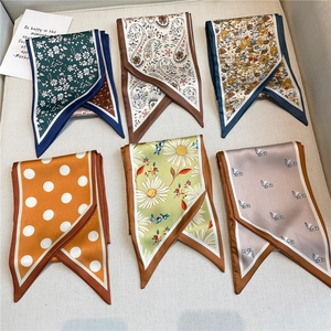 Détail de six élégants foulards twilly en satin aux motifs floraux et rétro variés