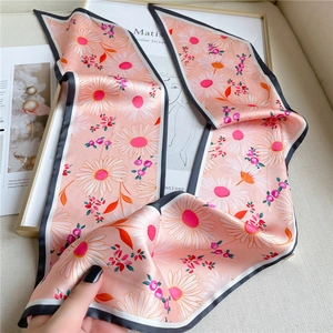 Détail d'un foulard étroit en soie à motif marguerites et bordures contrastées