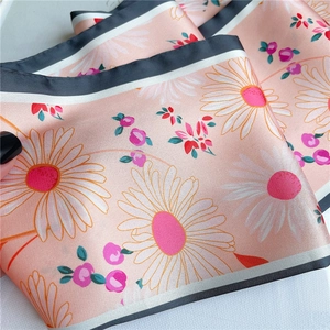 Détail d'un foulard en soie avec motifs de marguerites et bordures contrastées noir et blanc