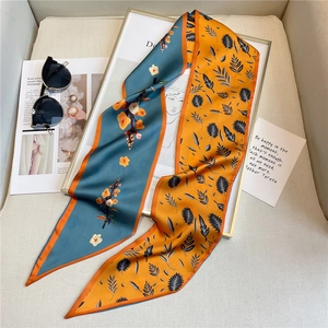 Gros plan d'un foulard en soie double face avec motifs floraux et de plumes