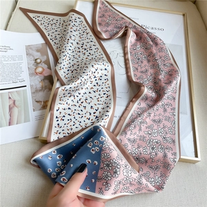 Détail d'un foulard étroit en soie à motifs floraux et léopard pour cheveux ou sac