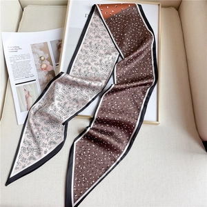Détail d'un foulard en soie double face montrant les motifs fleurs et pois