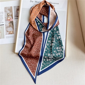 Détail d'un foulard en satin imprimé avec pois et motifs floraux artistiques