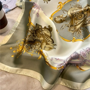 Dettaglio di sciarpa di lusso in seta con stemma vintage su fondo morbido